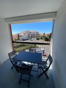 una mesa azul y sillas en un balcón con vistas en Joli T2 Centre port résidence Quai d'Honneur, en Cap d'Agde