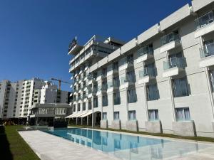 a building with a swimming pool in front of it at Hotel do Parque in Viana do Castelo