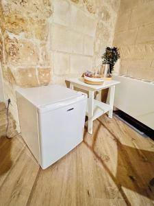 un tavolino bianco accanto a una vasca da bagno bianca di Alle Grotte a Matera