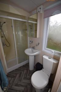 y baño con aseo, lavabo y ducha. en Tim's Getaways Super Caravan A2, Todber Valley Caravan Park, en Gisburn