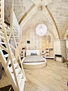 een slaapkamer met een groot bed en een trap bij Alle Grotte in Matera