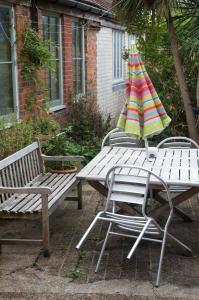 duas mesas de piquenique com um guarda-chuva em cima em Cissbury em Midhurst