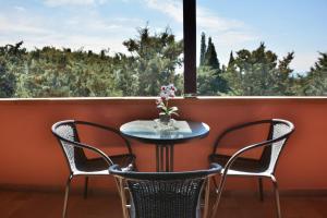 里帕貝拉的住宿－Hotel Villa Paradiso，阳台设有一张桌子和两把椅子,并设有一个窗户