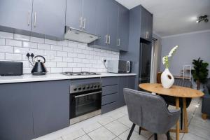 プレトリアにあるComfy Hatfield Appartmentのキッチン(青いキャビネット、木製テーブル付) +23枚の写真