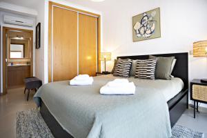 2 Betten in einem Hotelzimmer mit Handtüchern darauf in der Unterkunft Pink House in Faro