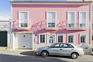 a pink house with a car parked in front of it at Pink House in Faro