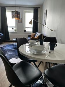 a table and chairs with plates and bowls on it at Studio King'sRoad in Kuopio