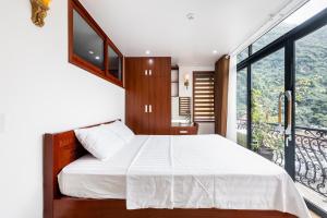 a bedroom with a large bed and a balcony at CHÉRIE HOMEHOTEL in Ha Long