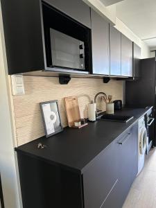 a kitchen with a black counter top and a microwave at Studio King'sRoad in Kuopio