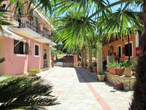 un patio de una casa con palmeras y plantas en Artemis Vassilikos en Vasilikós