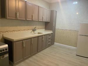 a kitchen with a sink and a refrigerator at Nuzhat Al Naseem Hotel in Mecca