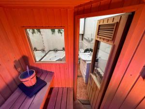an orange bathroom with a tub and a sink at Cal Foraster in Estorm