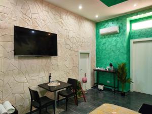 a dining room with a television on a wall at Suite Amazzonia in Taranto