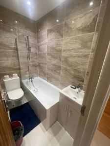 2 Bedroom Apartment,Chester Road N17 في لندن: حمام مع حوض ومغسلة ومرحاض