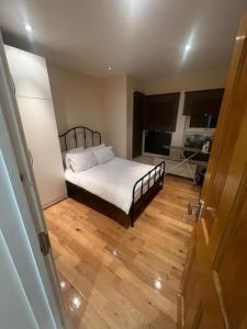 una camera con letto e pavimento in legno di 2 Bedroom Apartment,Chester Road N17 a Londra