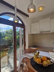 a kitchen with a bowl of fruit on a table at Studio apartman Karla in Rijeka