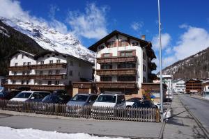 ein großes Gebäude mit davor geparkt in der Unterkunft Rosenheim in Saas-Grund