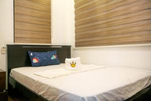 a bedroom with a bed with two pillows on it at Casa Amanda bungalow with hi-speed internet in Coron