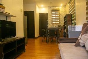 a living room with a couch and a tv at Casa Amanda bungalow with hi-speed internet in Coron
