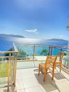 a balcony with two chairs and a view of the ocean at Narr Hotel in Kaş