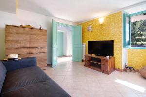 a living room with a couch and a flat screen tv at La Fermenteria in San Colombano Certenoli