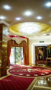 un vestíbulo con una gran alfombra roja y una lámpara de araña en Boutique Spa Casino Hotel Lybid Plaza en Khmelʼnytsʼkyy