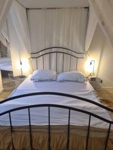 a large white bed with two pillows and two lamps at La parenthèse in Marche-en-Famenne