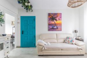 a living room with a couch and a blue door at Coqueto y Luminoso en la Playa de La Arena in La Arena