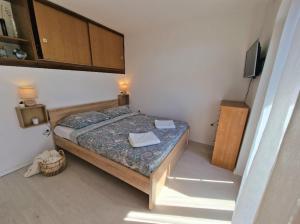 a small bedroom with a bed and a television at Studio apartman Karla in Rijeka