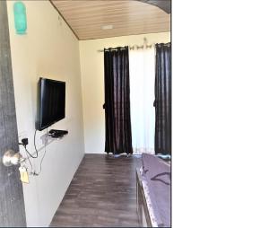 una camera con TV a schermo piatto e una camera da letto di Western Valley Cottages , Panchagani a Panchgani