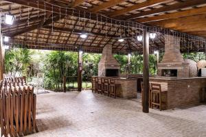 un patio con un bar al aire libre y una cocina al aire libre en Condomínio Edifício Allamanda - Módulo 6, en Bertioga