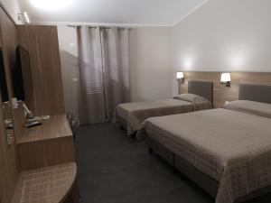 a hotel room with two beds and a television at Il Gabbiano in Termini Imerese