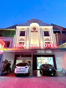 un hotel con dos coches estacionados frente a él en Thinh Gia Hotel, en Bến Cát