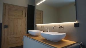 un bagno con due ciotole bianche su un bancone con uno specchio di Villa am Wappach a Bayerisch Gmain Altre 33 foto