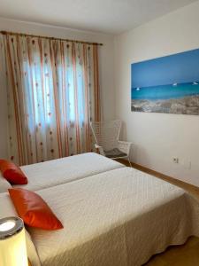 a bedroom with a bed and a painting on the wall at Apartamentos Ferrer in Es Figueral Beach