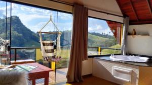 a bathroom with a large window with a view of a mountain at Chales Sabor Dos Ventos in Gonçalves