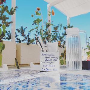 特拉尼的住宿－B&B LA GRAZIA，一张桌子,上面有一瓶水和一个标志