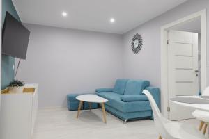 ein Wohnzimmer mit einem blauen Sofa und einem Tisch in der Unterkunft Apartament z Balkonem in Bad Königsdorff-Jastrzemb