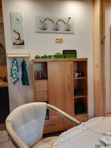 a white chair sitting in front of a wooden cabinet at Steinhaus / Kamenny Dum in Zdíkov