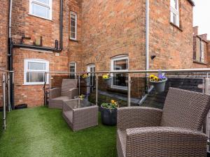 a balcony with wicker furniture and a brick building at The Eastgate Apartment in Louth