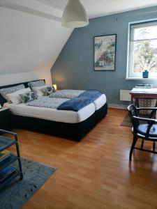 1 dormitorio con cama y pared azul en Gutshaus Dämelow Wismar en Dämelow