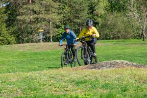 dos personas montando bicicletas en un campo de hierba en Kisakallion Urheiluopisto, Lohja, en Lohja