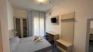 - une chambre avec un ours en peluche posé sur un lit dans l'établissement Hotel La Giara, à Zambrone