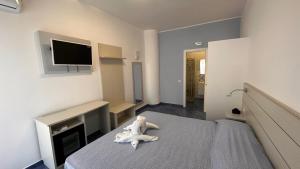 - une chambre avec un ours en peluche posé sur un lit dans l'établissement Hotel La Giara, à Zambrone