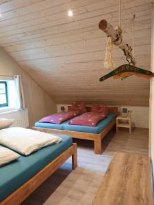 um quarto com 2 camas e um snowboard pendurado no tecto em Steinhaus / Kamenny Dum em Zdíkov