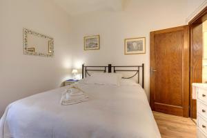 フィレンツェにあるCasa Campuccio -Appartamento Campuccio1 e Appartamento Campuccio 2のベッドルーム1室(白いシーツと鏡付きのベッド1台付)