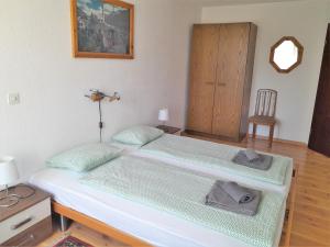 a bedroom with two beds with a chair and a door at Onyx in Locarno