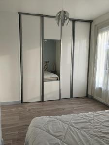 - une chambre dotée d'armoires avec miroir et d'un lit dans l'établissement Horizon, à Saint-Valery-en-Caux