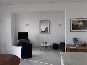 - un salon avec une table et une télévision dans l'établissement Horizon, à Saint-Valery-en-Caux