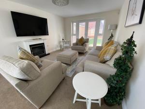 a living room with two couches and a tv at Westergate - 4 Bed Luxury Home with free parking in Milton Keynes